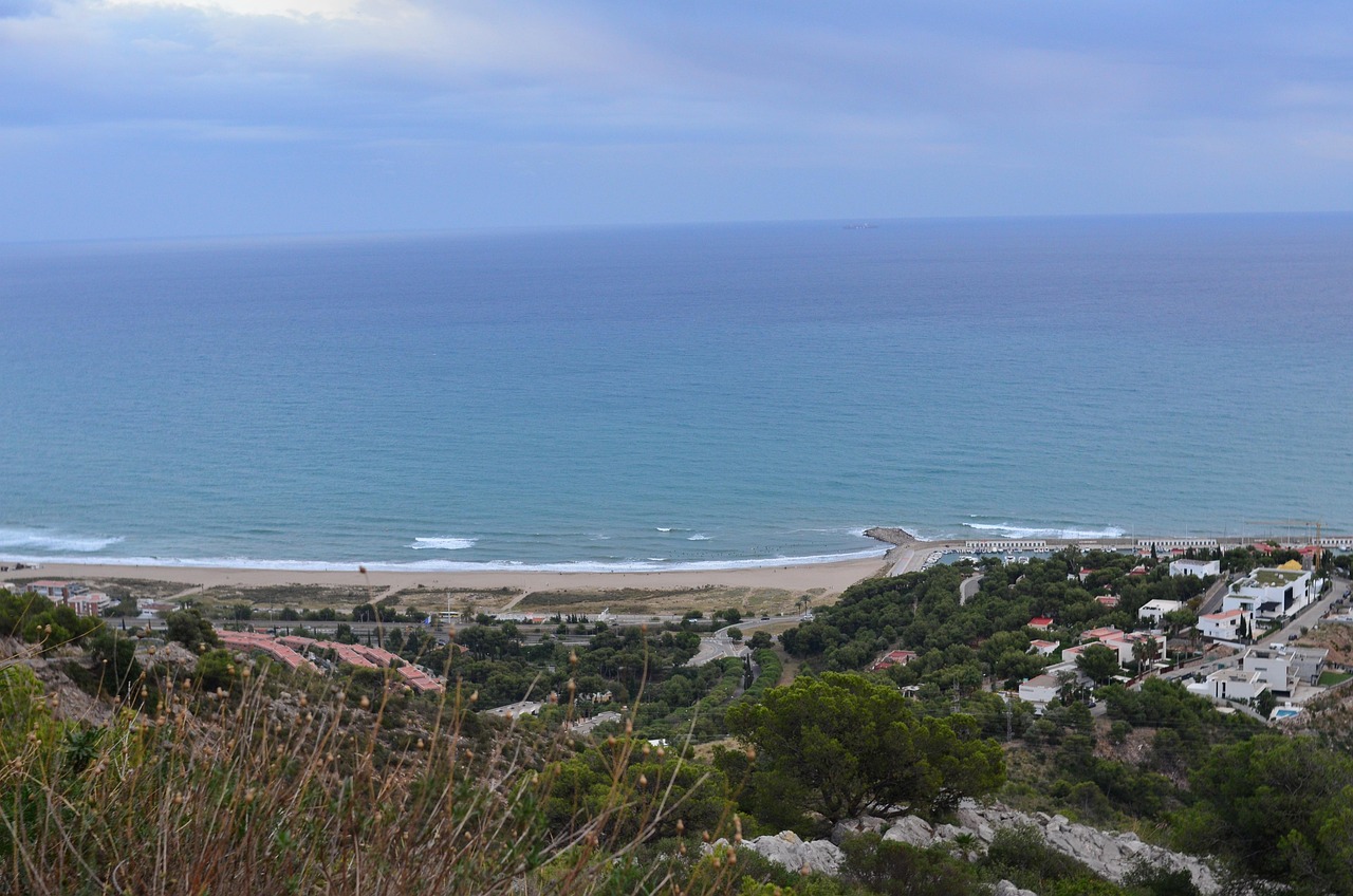 Castelldefels beach south of Barcelona seen from the hills, a long curve of sand and calm blue sea where the gold ring was lost and found