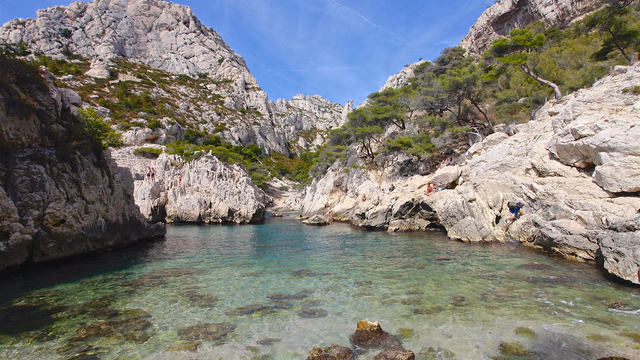 White limestone cliffs dropping into clear turquoise water in a calanque near Marseille, the kind of rocky inlet where a lost ring falls straight to the sea floor