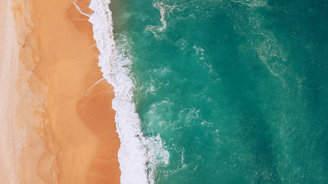 Golden sand and turquoise surf along the beach at Surfers Paradise on the Gold Coast with the high-rise skyline behind, a busy surf beach where a lost ring or wedding band can quickly sink into the sand