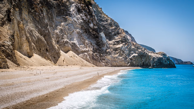 Turquoise water and pale sand in a pine-lined cove on Menorca, the kind of beach at Cala Macarella where a lost ring usually stays close to where it fell