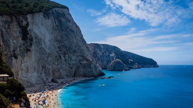 A small Mediterranean cove with a strip of sandy beach, clear turquoise shallow water and rocks along the edge, the three kinds of ground where a lost ring can end up